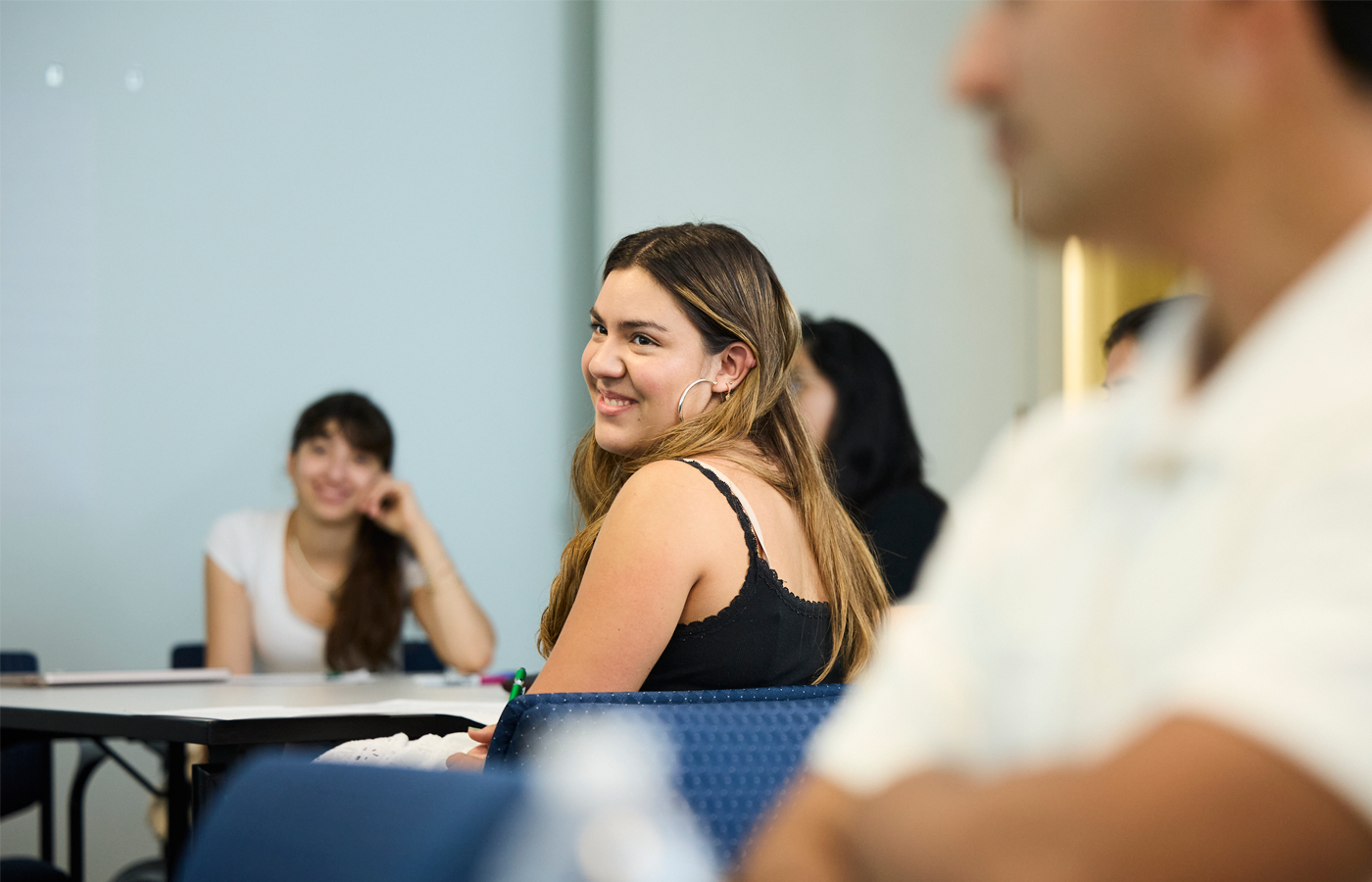 Student smiling in a classroom at Sophomore Summer