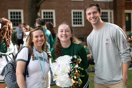 A student cheerleader with their family. 