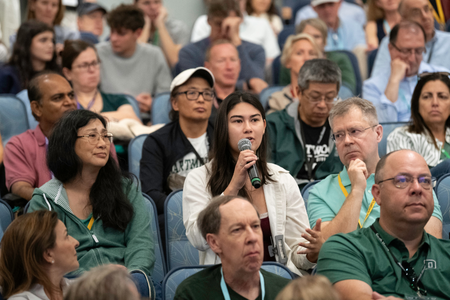 A student with their family asking a question during President Beilock's address. 