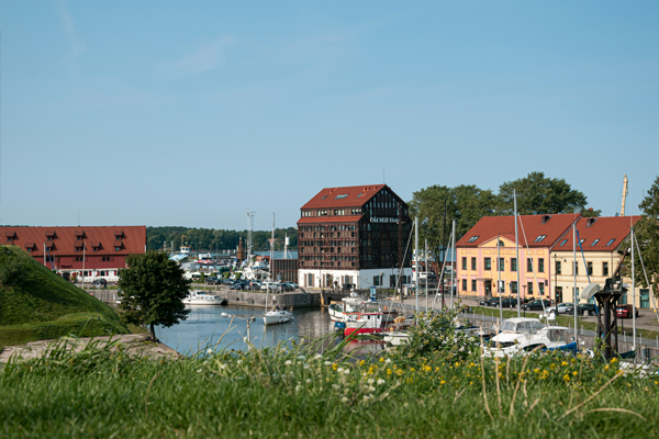 Little boats sitting in a harbor with quaint buildings behind it