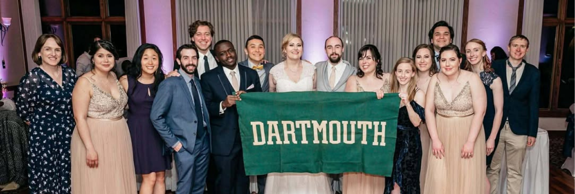 The couple holding a Dartmouth banner in a group shot.