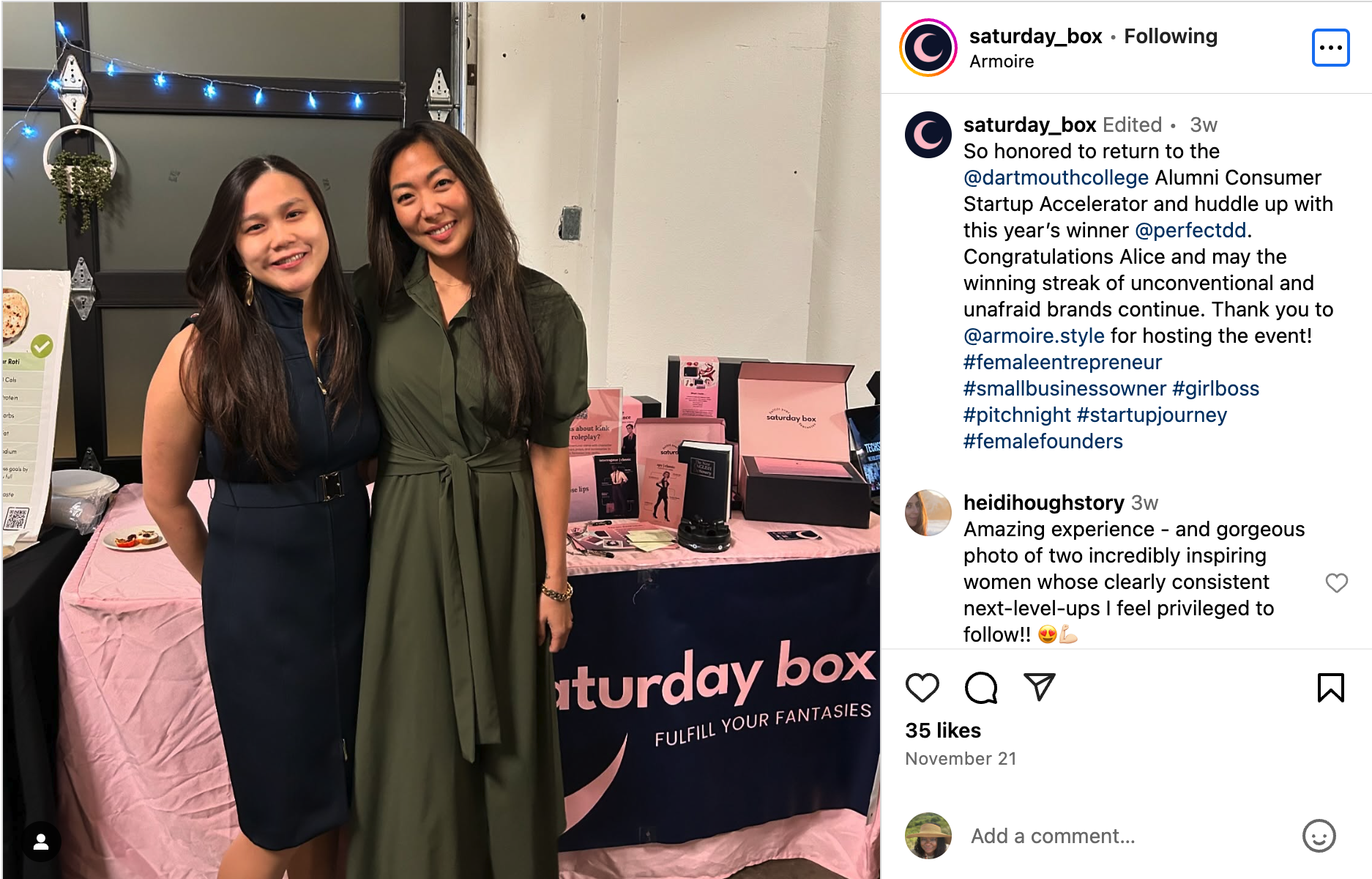 Two women posing in front of a table with Saturday Box items. 