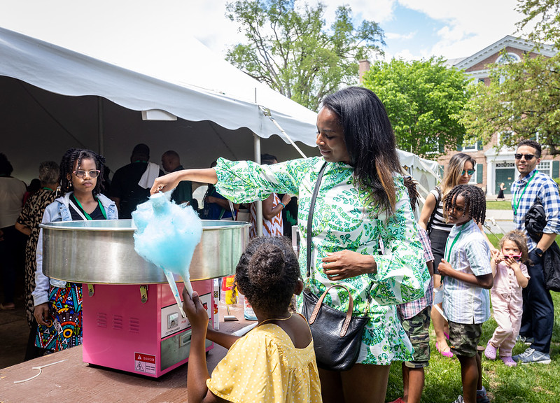 A mom and child getting cotton candy at a picnic