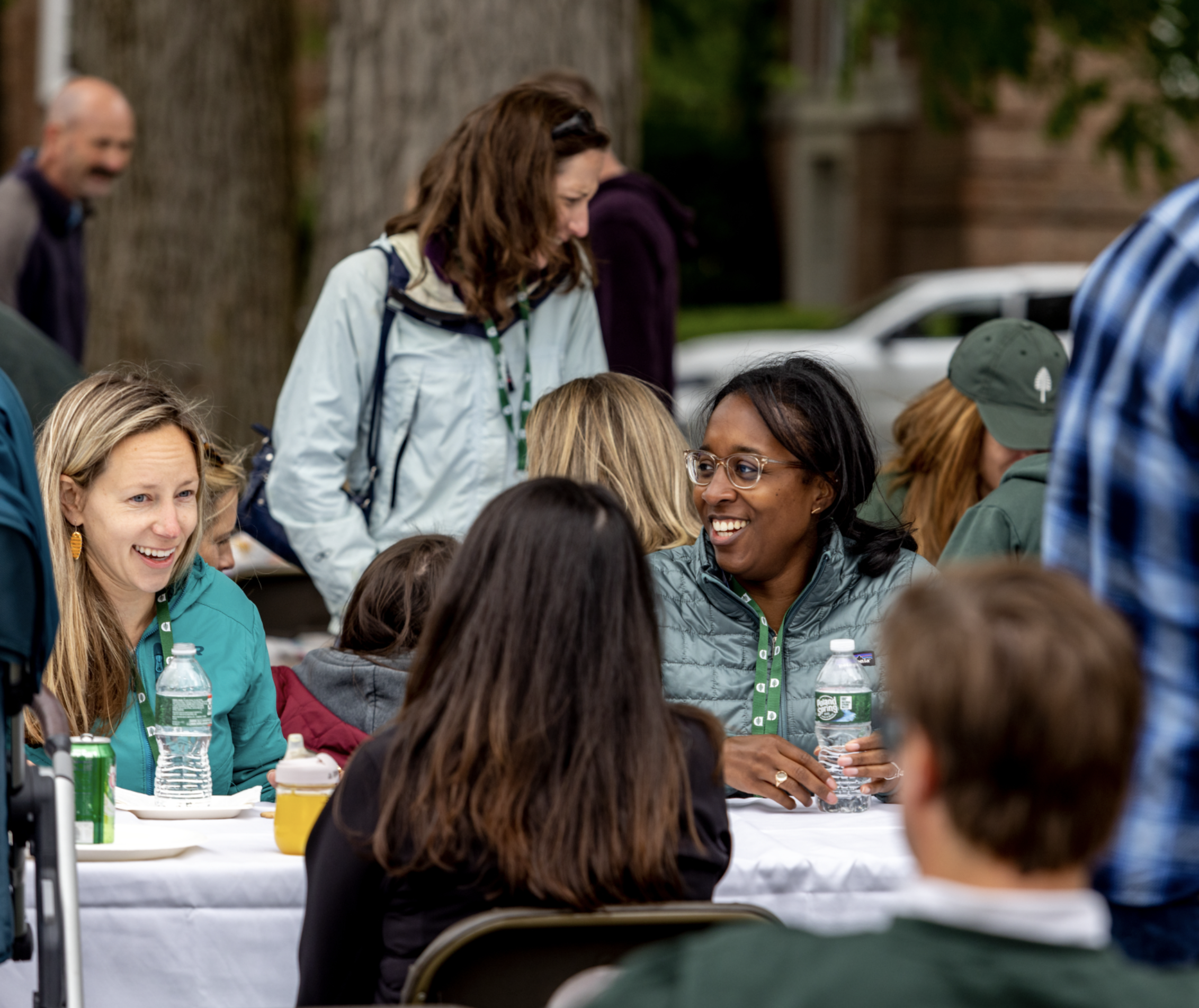 Alumnae seated at a table outdoors talking