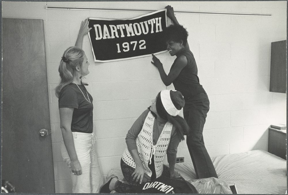 Dartmouth women in 1972 hanging a banner in a dorm room