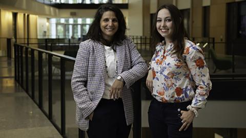 A photo of professor Karen Fortuna (left) standing next to student Julia Hill (right).