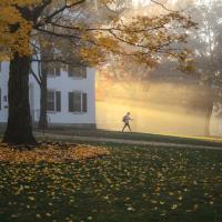 young woman walking in morning sunlight from Dartmouth Hall
