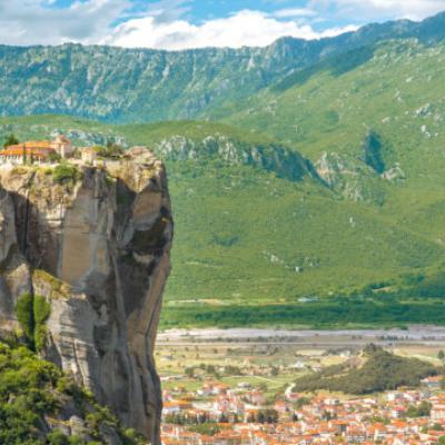 Overlooking the town of Meteora, where a mansion rests atop a cliff above the rest of the city.